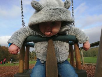 Close-up of boy on swing at playground