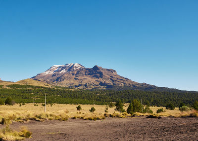 Scenic view of mountains against clear blue sky