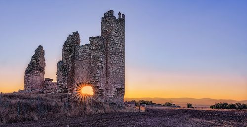 Panoramic view of illuminated building against sky during sunset