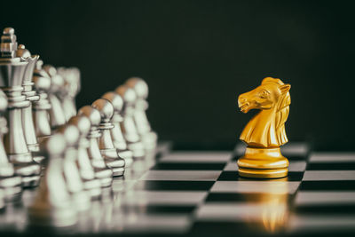 Close-up of chess pieces on board against black background