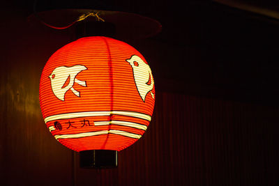 Low angle view of illuminated lantern hanging at night