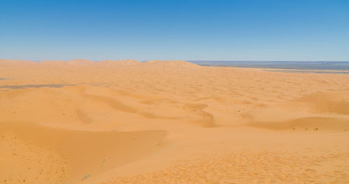 Scenic view of beach against clear blue sky