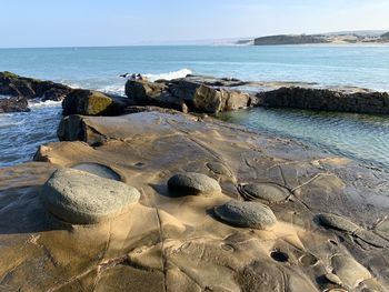 Rocks on beach against sky