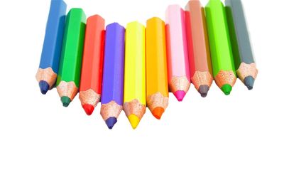 High angle view of colored pencils against white background