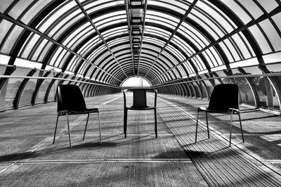 Empty chairs on covered footbridge