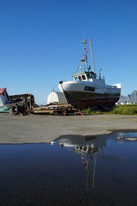 Ship moored on sea against clear blue sky