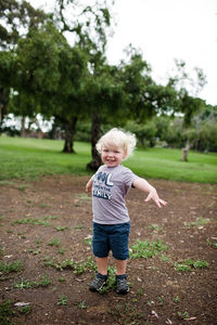 Full length of smiling girl standing on land