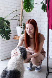 Young woman playing with her cute dog at home. lovely pet