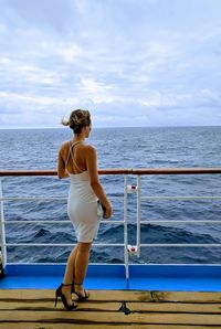 Woman standing on boat in sea against sky