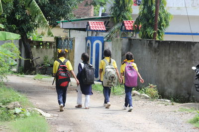 Rear view of people walking on footpath