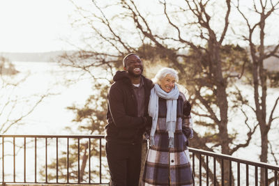 Happy male healthcare worker and elderly woman standing in park