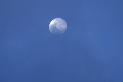 Low angle view of moon against blue sky