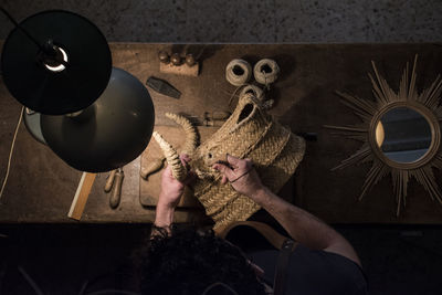 Artisan braiding a wicker bull's head in his workshop
