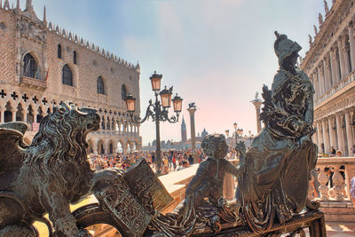 Sculpture of winged lion symbol of venice on stairs of san marco square against the palazzo ducale