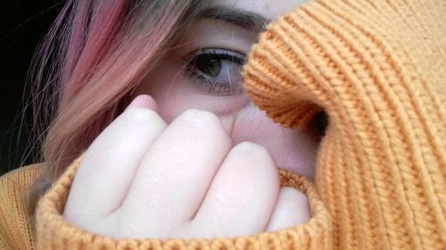 Close-up portrait of young woman covering face