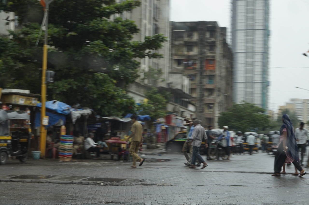 PEOPLE ON ROAD IN CITY AGAINST SKY