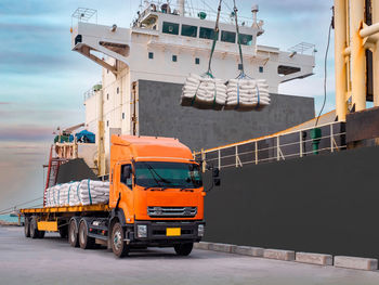 Sugar bags are loading in hold of bulk-vessel at industrial port.