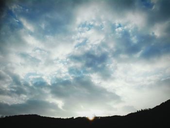 Low angle view of silhouette trees against sky