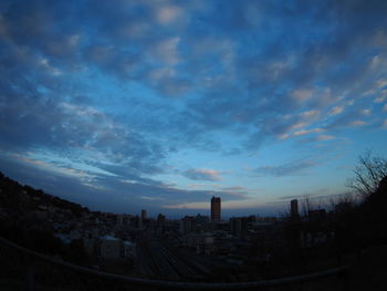 Buildings in city against sky at sunset