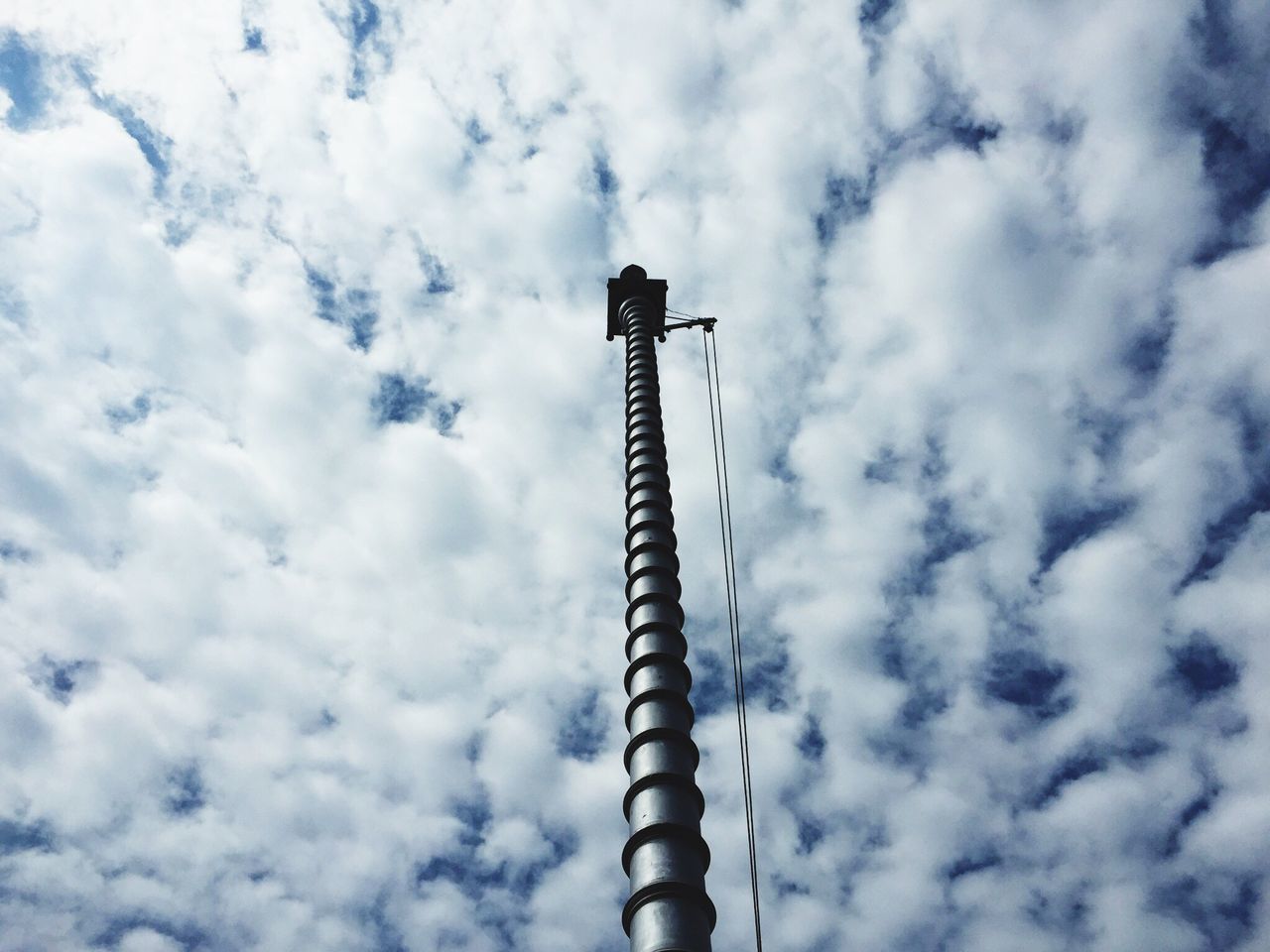 low angle view, sky, cloud - sky, cloudy, cloud, street light, pole, lighting equipment, tall - high, day, outdoors, no people, industry, built structure, metal, bird, nature, overcast, architecture, animal themes