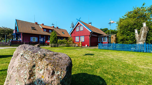 Lawn by building against clear blue sky