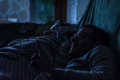 Smiling man with son lying down on bed