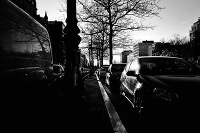Cars on road against sky in city