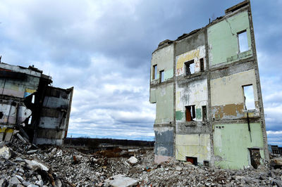 Abandoned built structure against cloudy sky