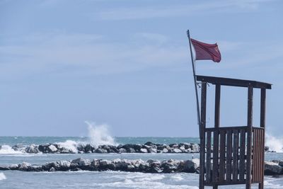 Observation hut with red flag by sea 