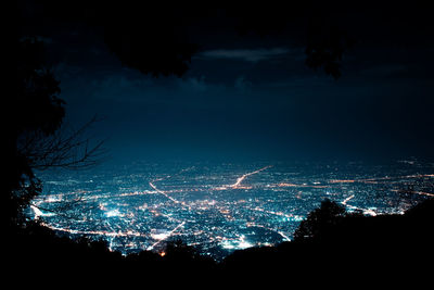 Illuminated cityscape against sky at night