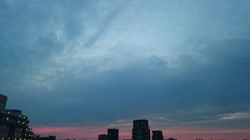 Low angle view of buildings against cloudy sky