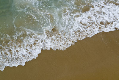 High angle view of waves rushing towards shore