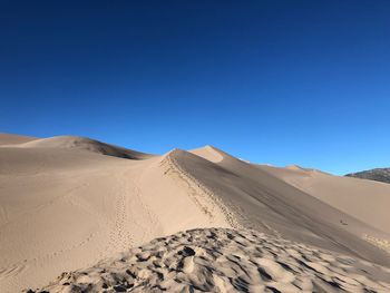 Scenic view of desert against clear blue sky