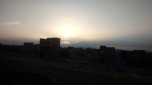 Silhouette cityscape against sky during sunset