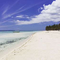 Scenic view of beach against blue sky