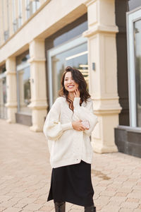 Young woman standing against building in city