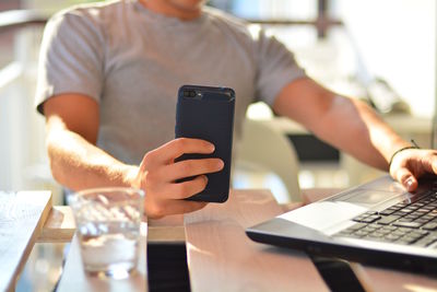 Midsection of man using mobile phone