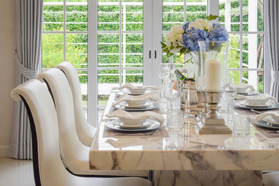 Potted plants on table by window at home