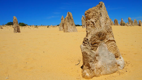 Low angle view of sand dune in desert against clear blue sky