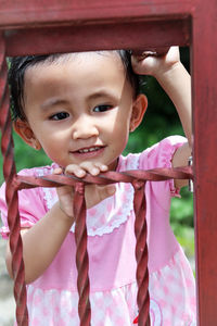 Close-up of baby girl looking through metal