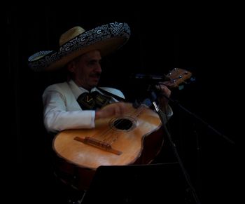 Young man playing guitar at music concert