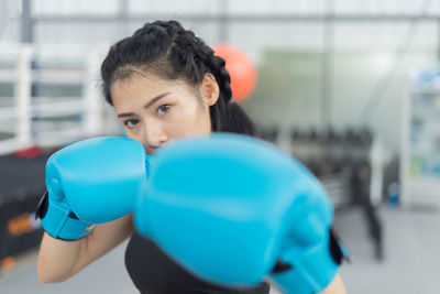Young woman with boxing gloves in gym