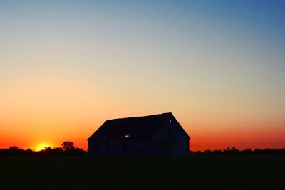 Silhouette building against sky during sunset