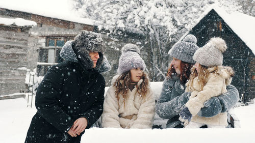 Winter family fun. happy family of 4 is enjoying of snow and snowfall, having fun outdoors