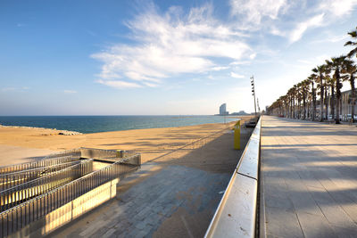 Footpath by sea against sky