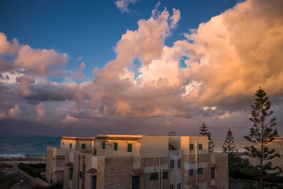 View of cityscape against cloudy sky