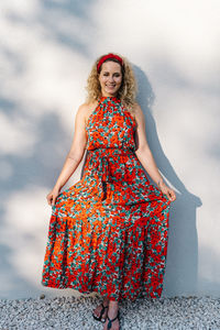 Portrait of smiling young woman standing against blurred background