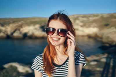 Portrait of smiling young woman wearing sunglasses