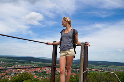 Young woman standing at observation point against townscape