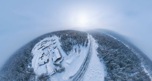 Aerial view of snow covered land against sky